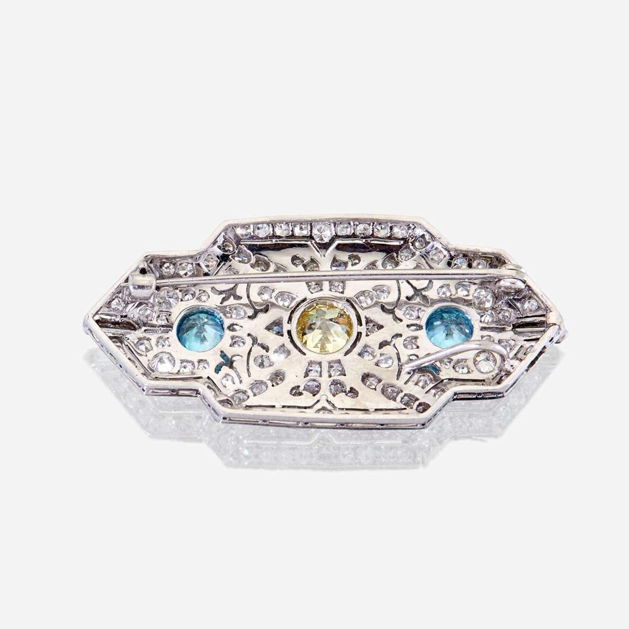 A yellow diamond, diamond, zircon, and fourteen karat white gold pendant/brooch, Raymond Yard