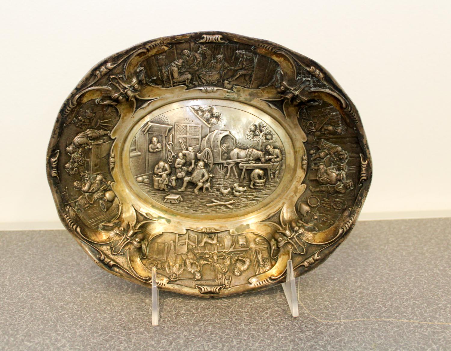 A Dutch Silver Bowl, 1854, of oval form, the border decorated with grotesque masks flanking cartouches depicting tavern scenes and cent