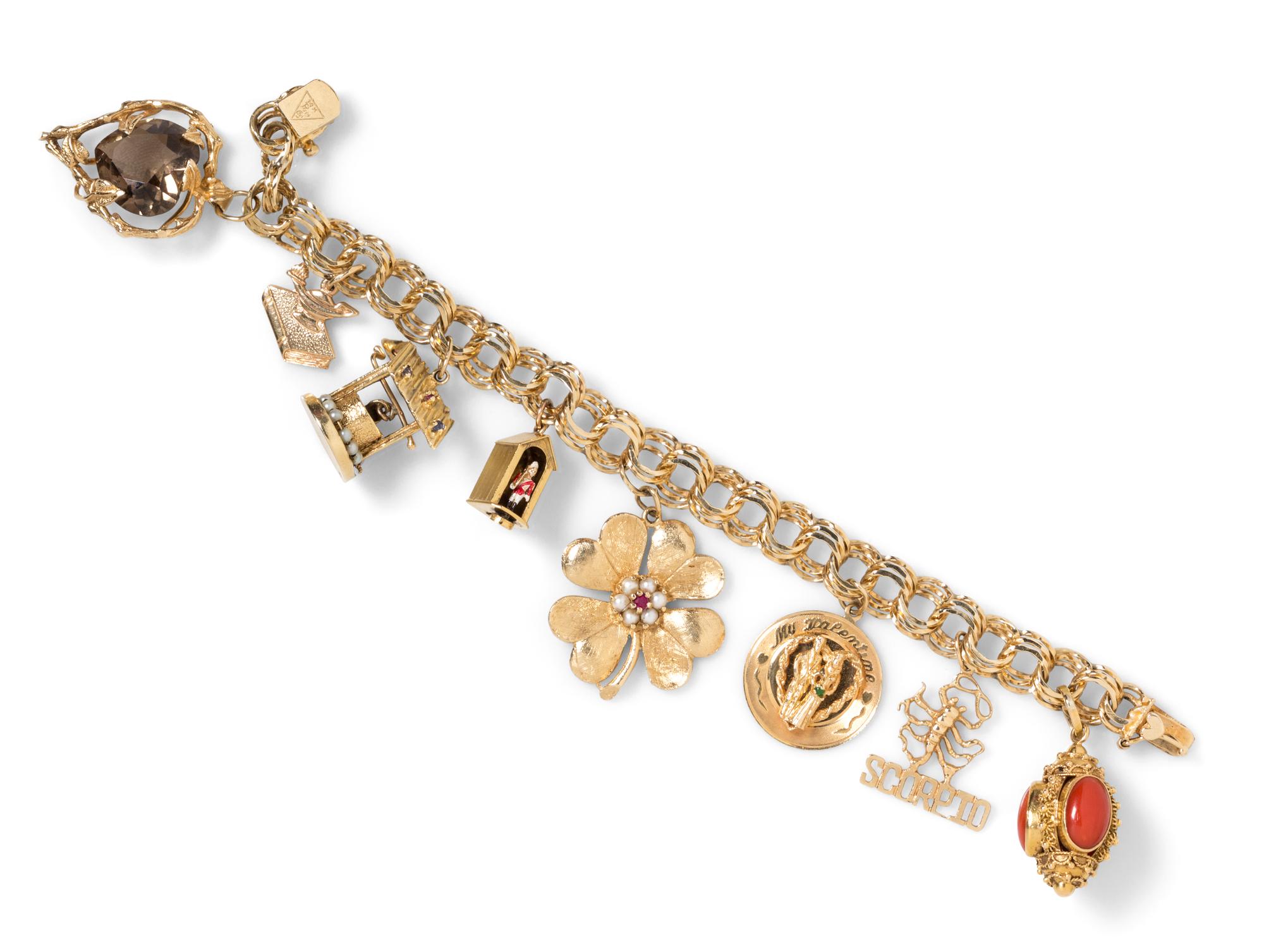 A 14 Karat Yellow Gold Charm Bracelet with 8 Attached Charms, 36.20 dwts.
