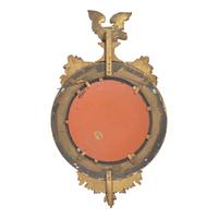 A Classical Giltwood and Parcel Ebonized Bull's Eye Mirror with Eagle