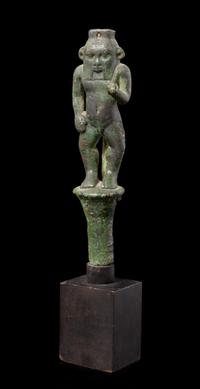 An Egyptian Bronze Bes Standing on a Papyrus Umbel Height 7 inches. — THIRD INTERMEDIATE PERIOD, DYNASTY 21-22, 1070-712 B.C.E.