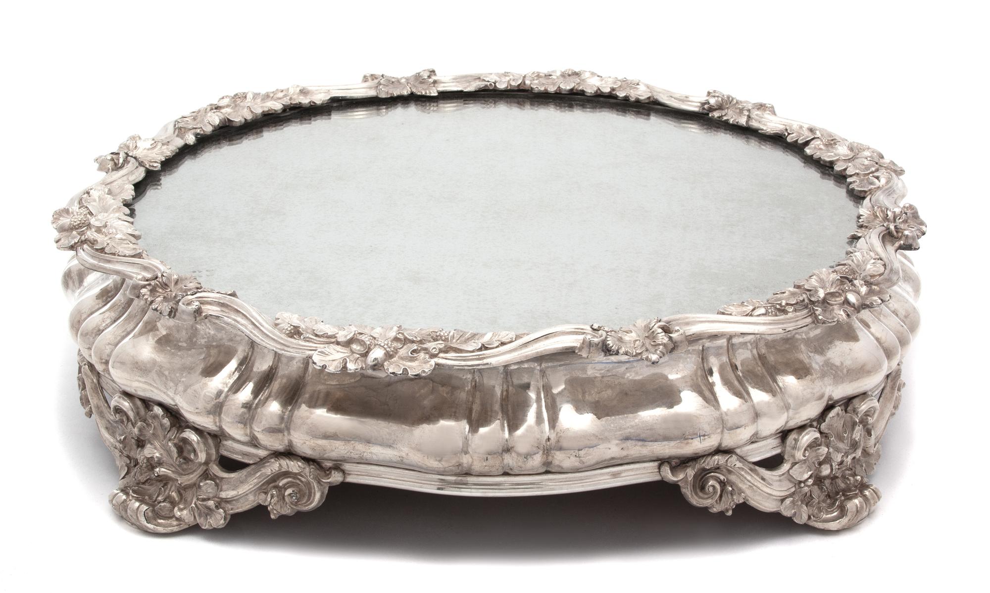 A Continental Silver Plate Mirror Top Plateau, 19TH CENTURY, having scrolll and oak leaf border and feet.