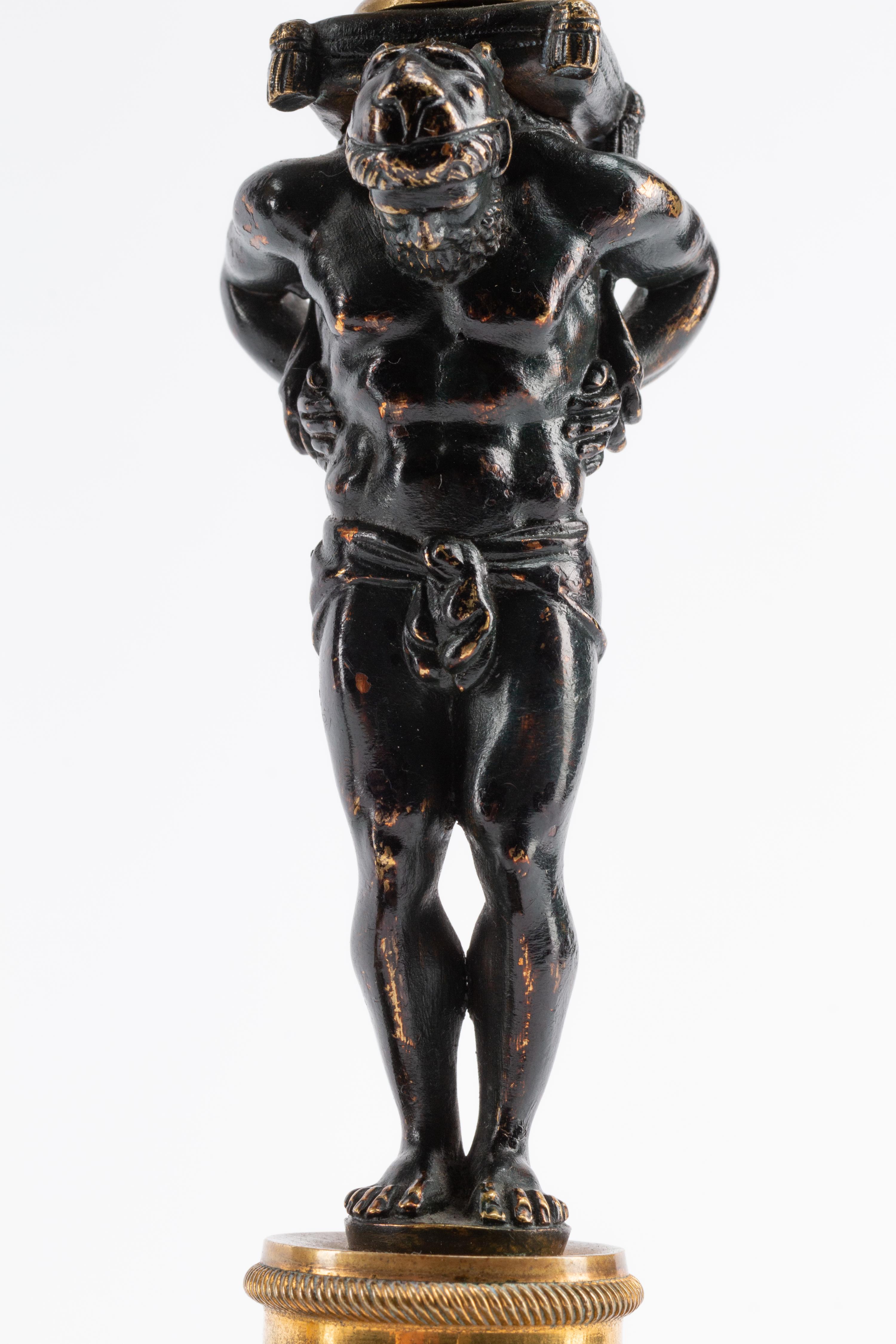 A Pair of French Gilt and Patinated Bronze and Marble Figural Candlesticks in the Form of Atlas