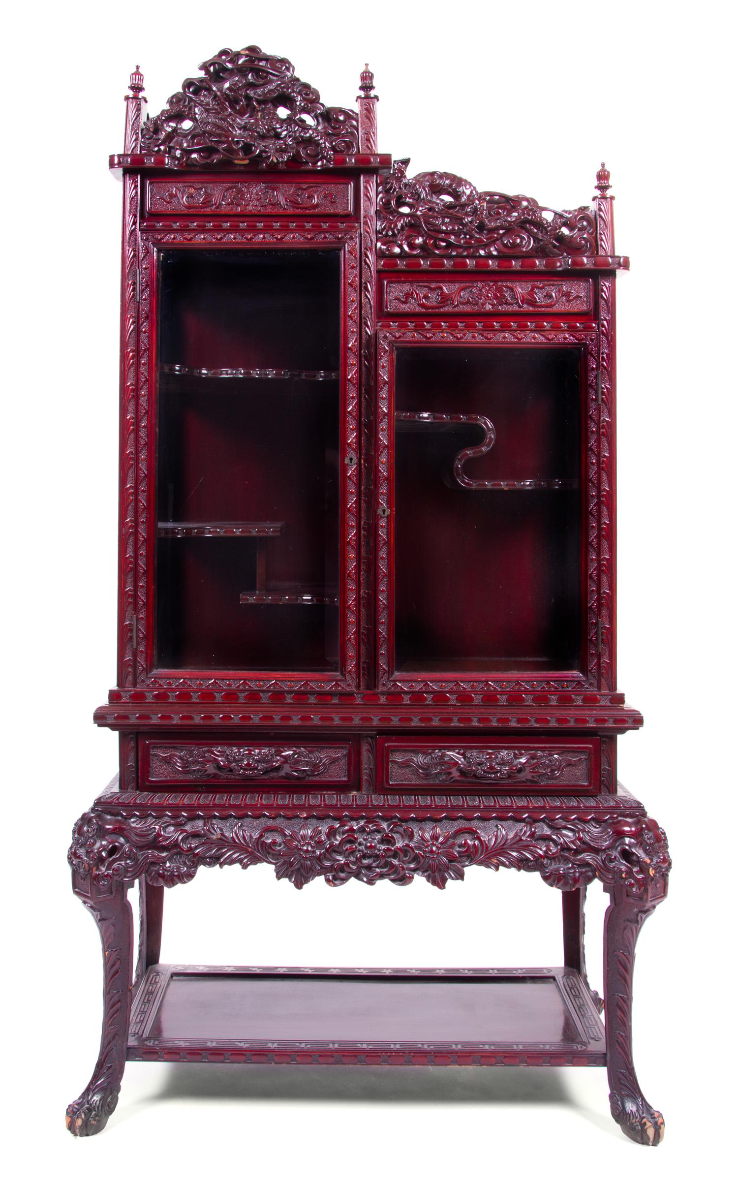 A Chinese Hardwood Carved Vitrine Height 63 1/2 x width 31 x depth 16 1/4 inches.
