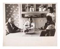 [KING, Martin Luther, Jr. (1929-1968)]. Press photograph of Dr. Martin Luther King, Jr. deep in discussion with Coretta Scott King and his parents, Martin Luther King, Sr. and Alberta King. 10 May 1964.