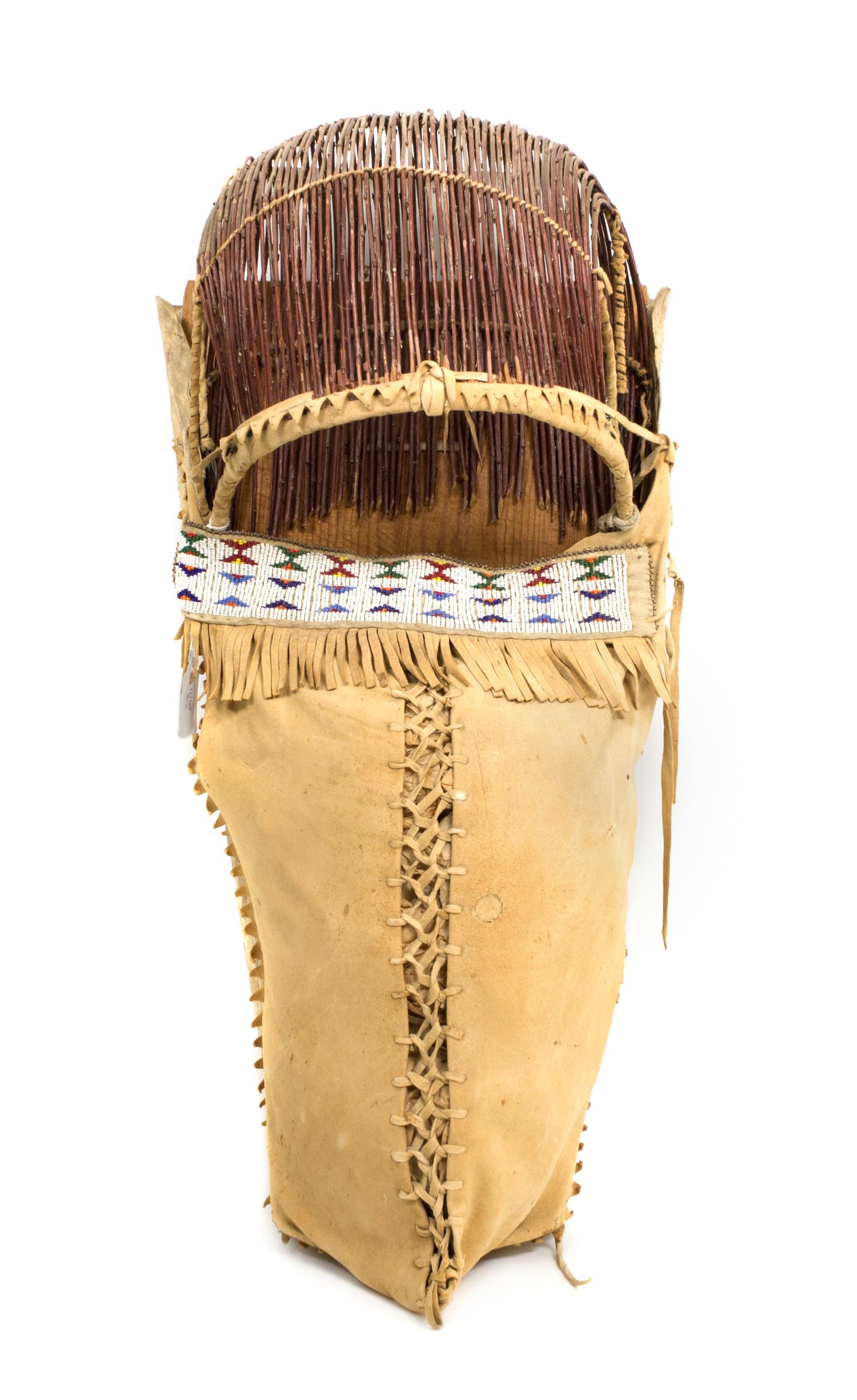 An Apache Wood, Hide and Twig Cradleboard Height 24 x width 11 3/4 inches. — 20th CENTURY