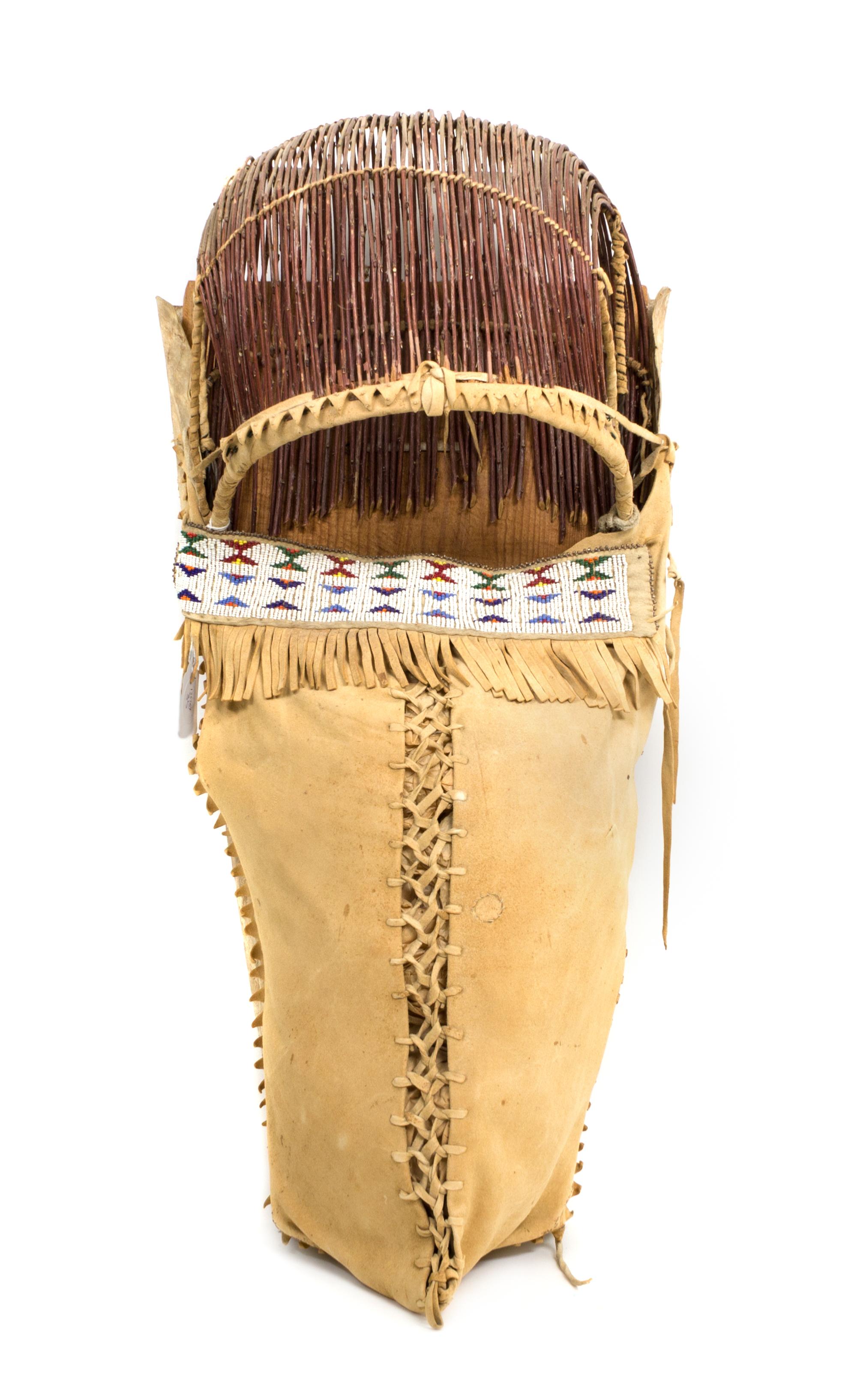 An Apache Wood, Hide and Twig Cradleboard Height 24 x width 11 3/4 inches. — 20th CENTURY