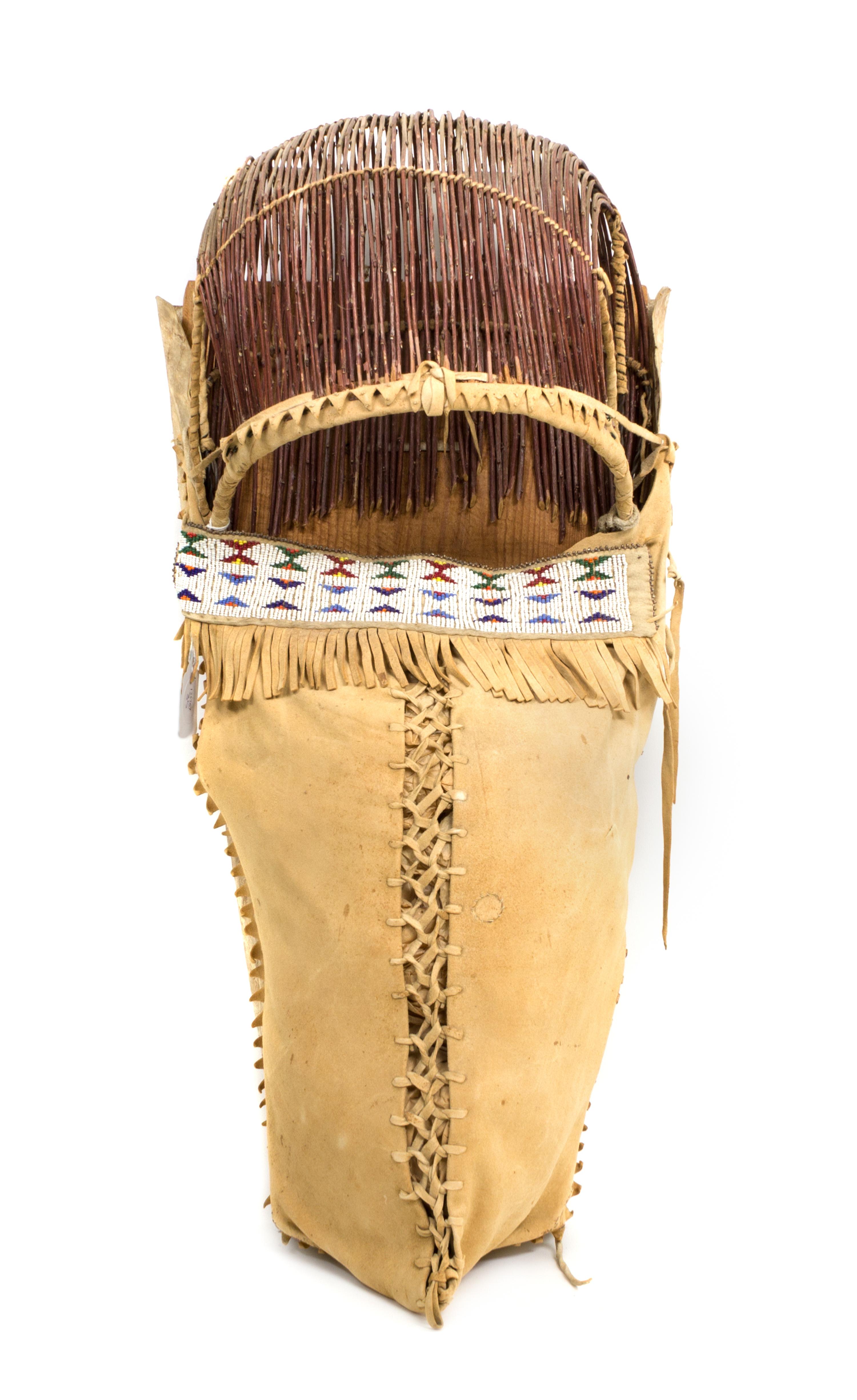 An Apache Wood, Hide and Twig Cradleboard Height 24 x width 11 3/4 inches. — 20th CENTURY