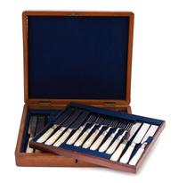 A 23-Piece Silver Plate and Carved Mother of Pearl Dessert Set, 19TH CENTURY, comprising 11 knives and 12 forks in a burlwood case.