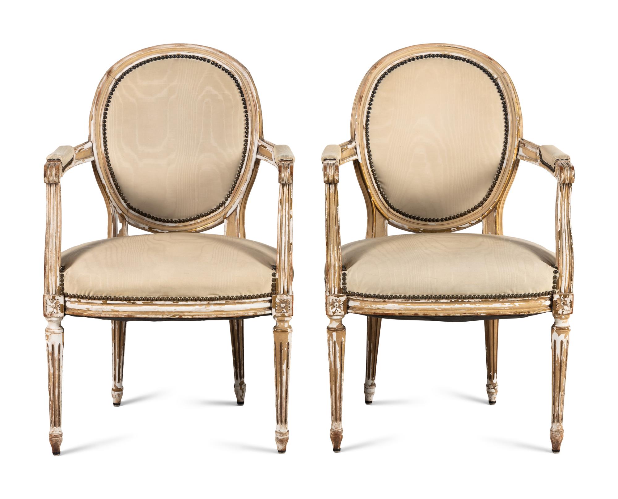 A Pair of Louis XVI Style Painted and Parcel Gilt Fauteuils