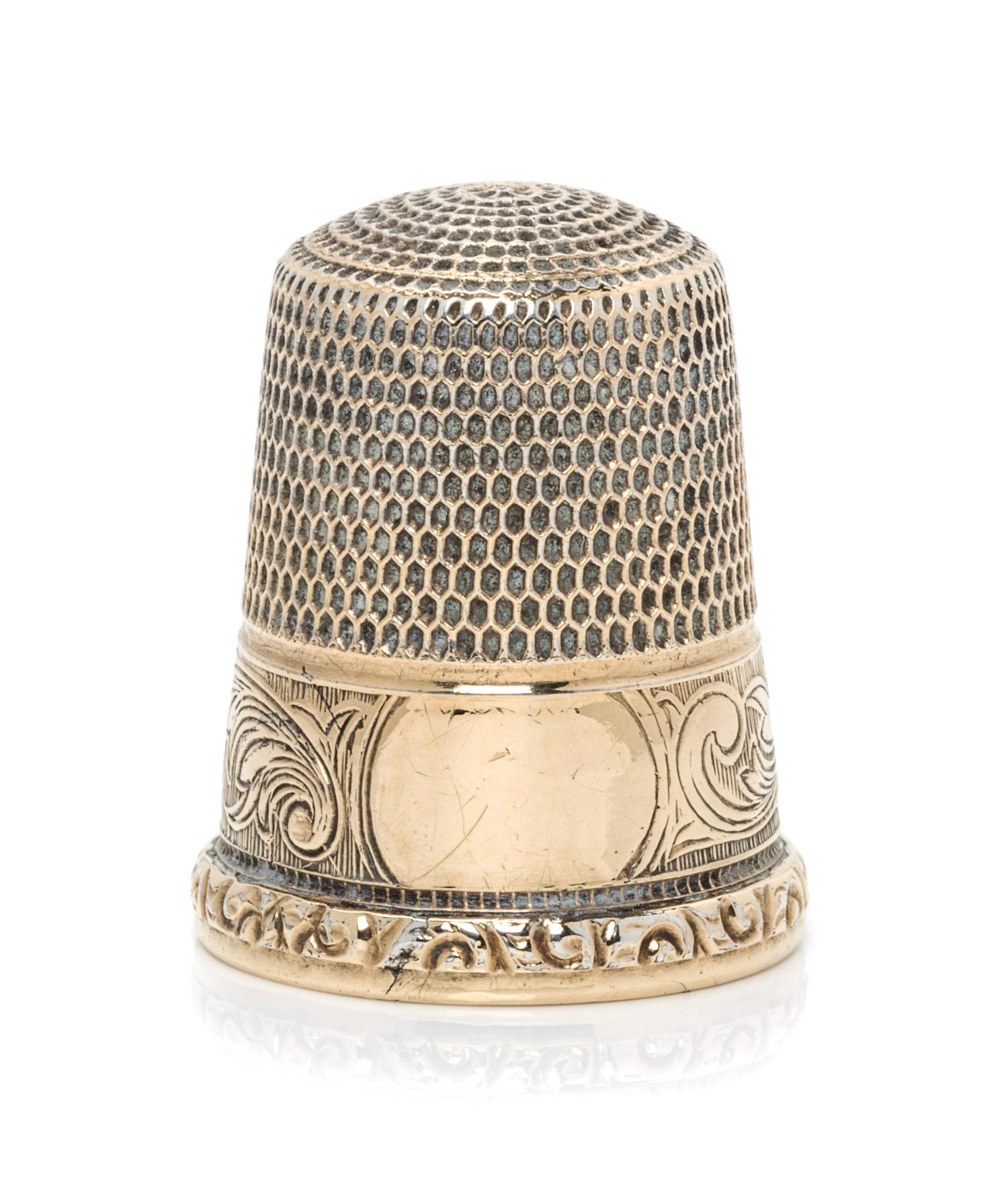 An American 14-Karat Gold Thimble, Simons Bros., Philadelphia, PA, the knurled top and body above a volute decorated band with a vacant