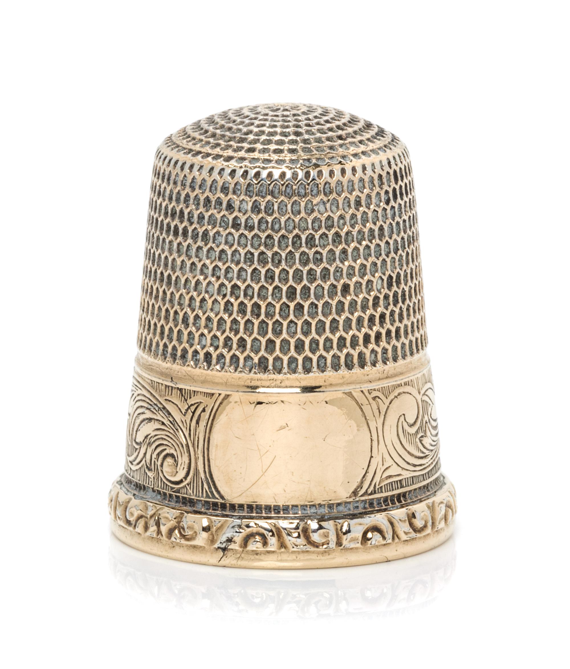 An American 14-Karat Gold Thimble, Simons Bros., Philadelphia, PA, the knurled top and body above a volute decorated band with a vacant