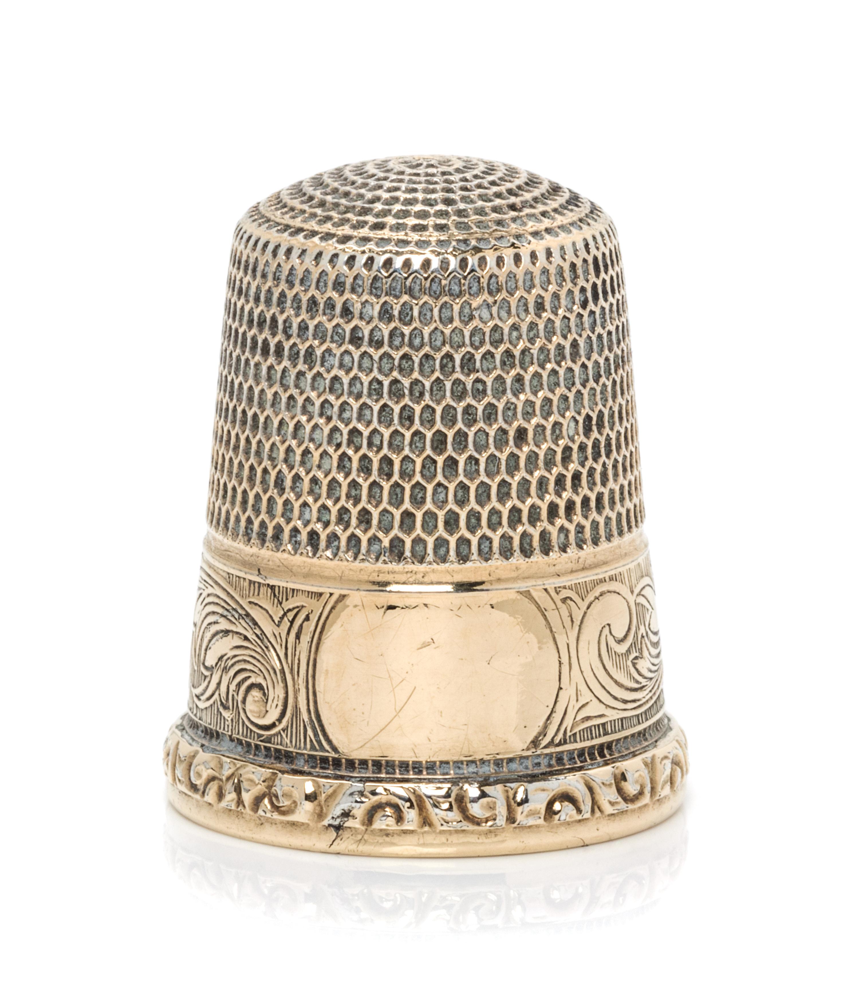 An American 14-Karat Gold Thimble, Simons Bros., Philadelphia, PA, the knurled top and body above a volute decorated band with a vacant