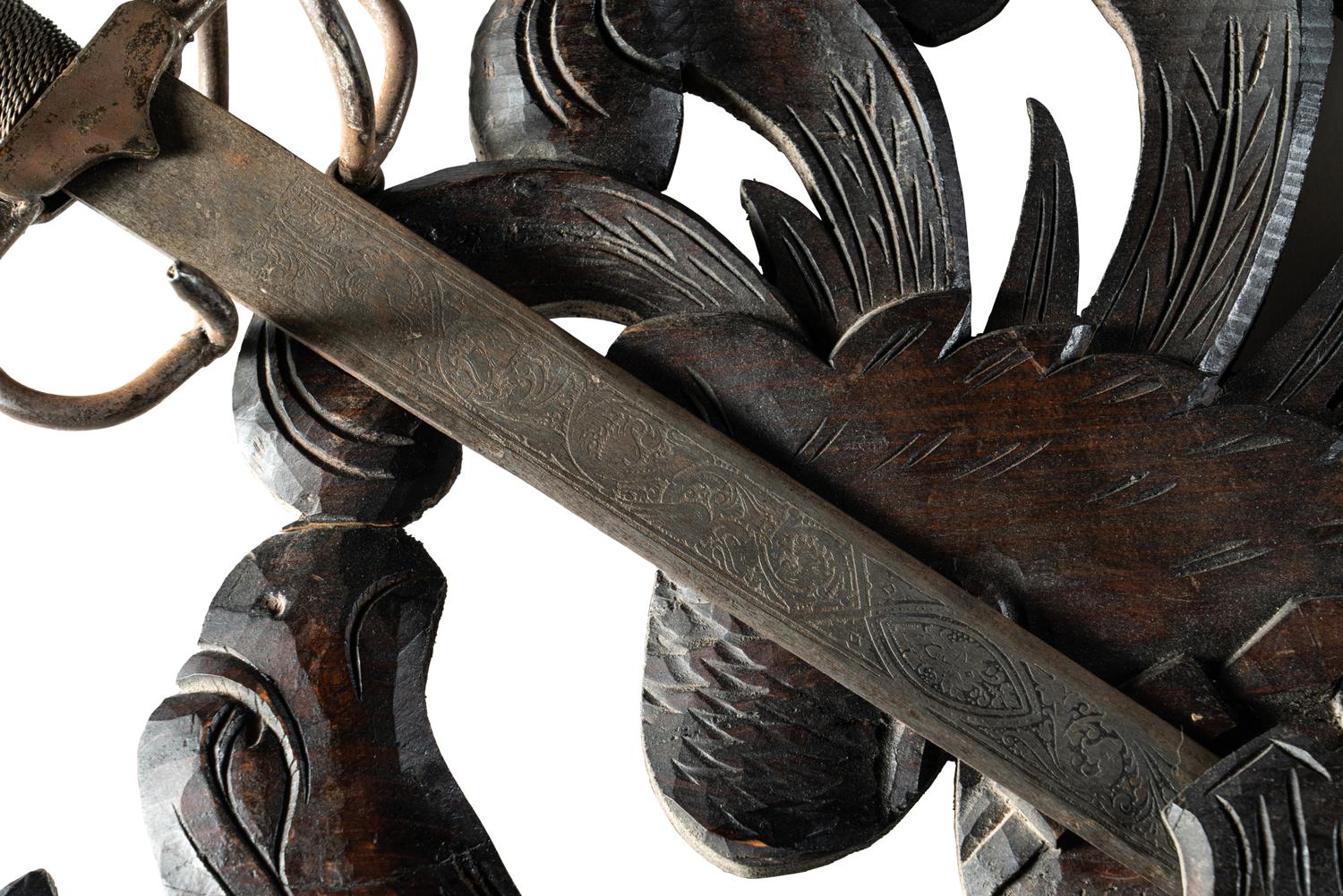 A Continental Carved Walnut Coat-of-Arms Plaque with Metal Crossed Swords