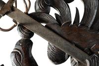 A Continental Carved Walnut Coat-of-Arms Plaque with Metal Crossed Swords