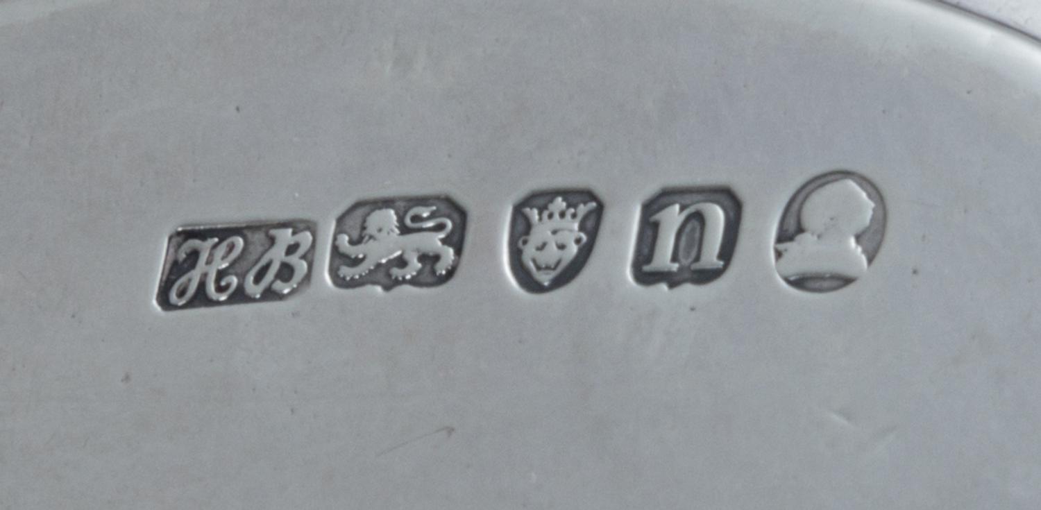 A George III Silver Stand, Hester Bateman, London, 1788, of oval form, having a central oval cartouche with an armorial depicting a lio