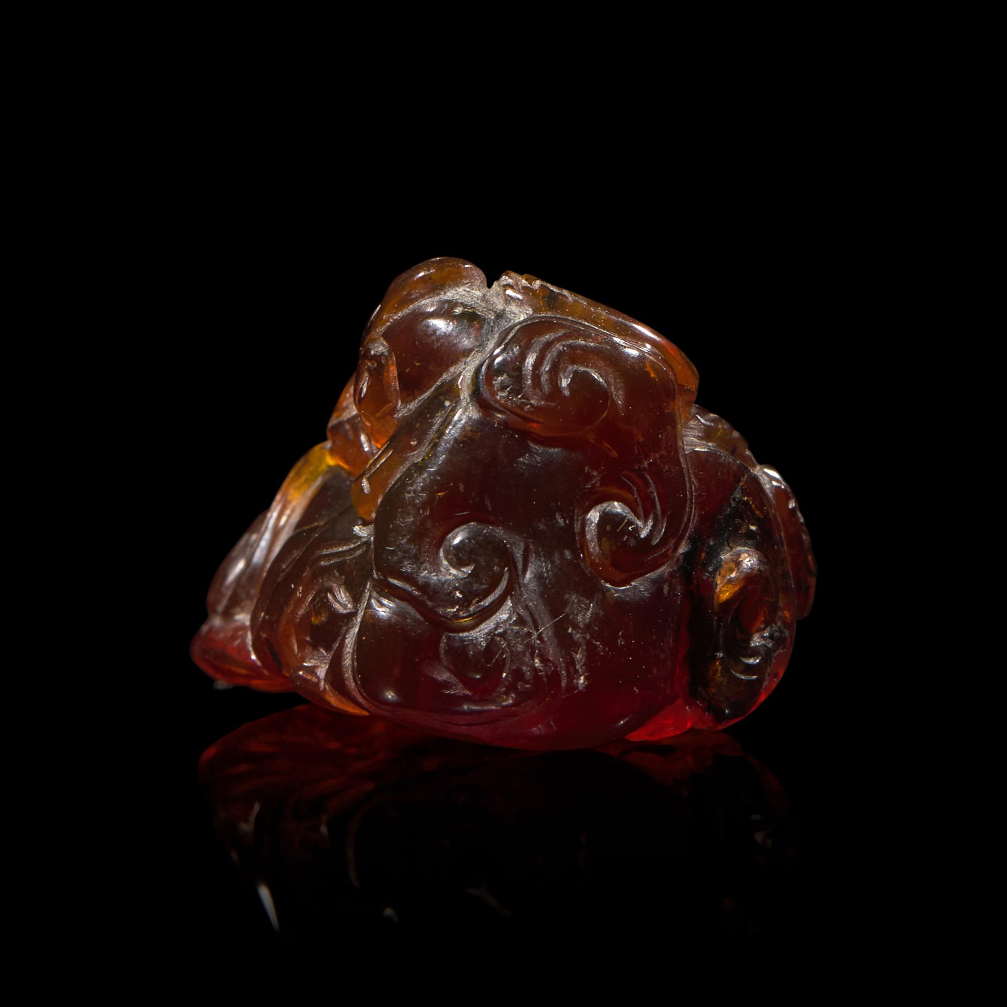 A Chinese Carved 'Bats and Shou-Lao' Amber Pendant, 18th-19th Century 清中期 五福捧壽琥珀把件