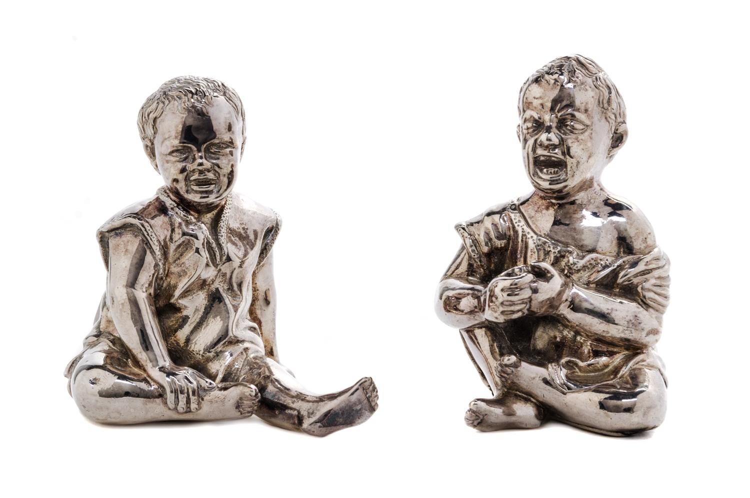 A Pair of Victorian Silver Figural Condiment Containers, Thomas Johnston II, London, 1886, each in the form of a seated child, one laug