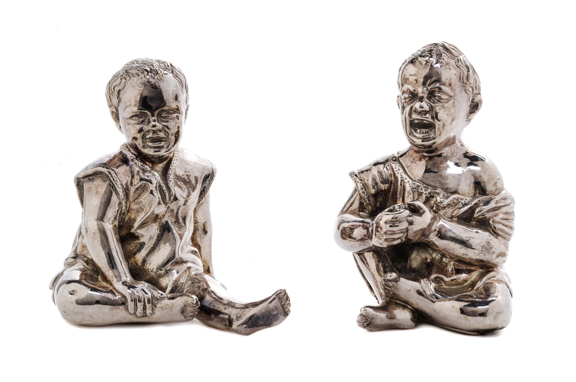 A Pair of Victorian Silver Figural Condiment Containers, Thomas Johnston II, London, 1886, each in the form of a seated child, one laug