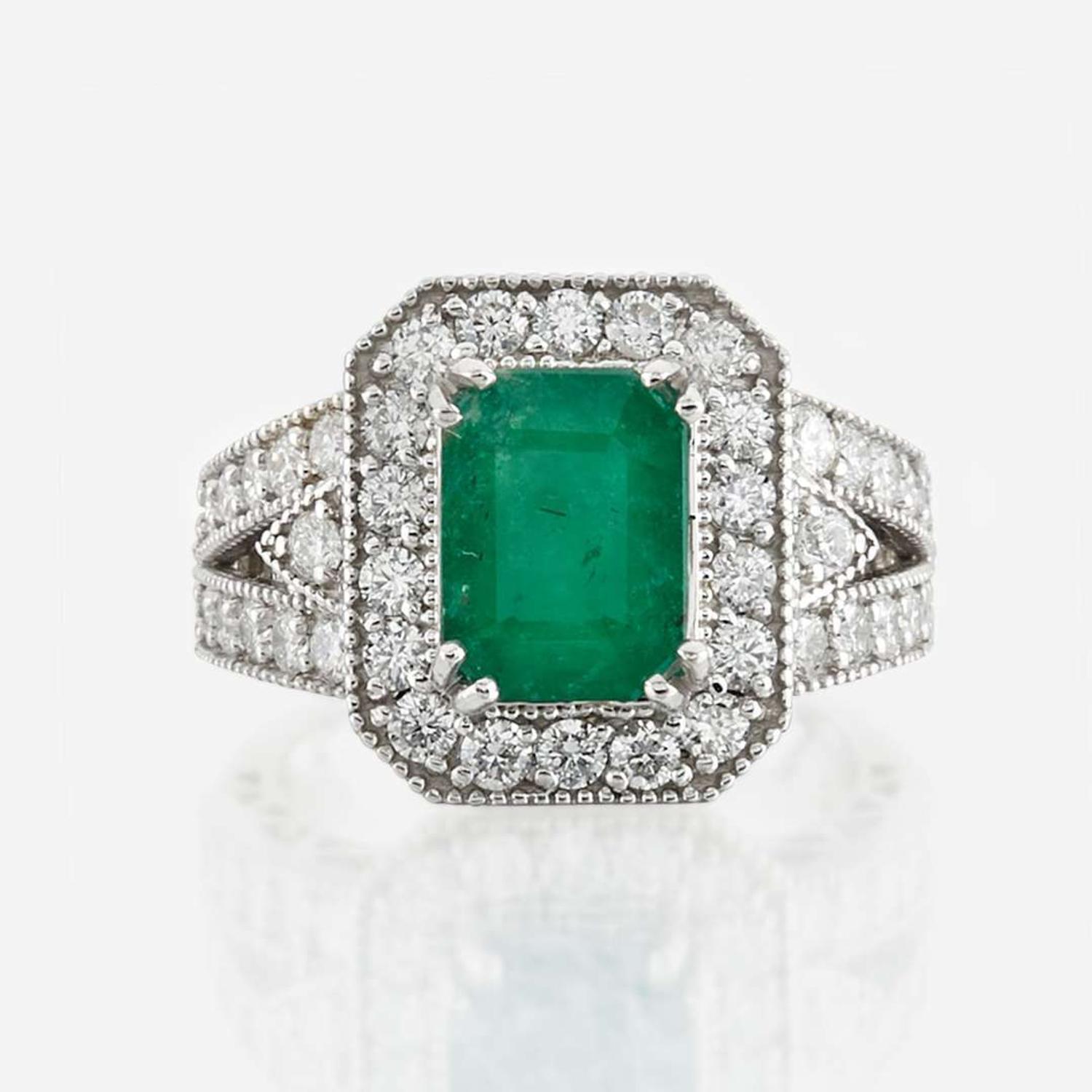 An emerald, diamond, and white gold ring