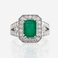 An emerald, diamond, and white gold ring