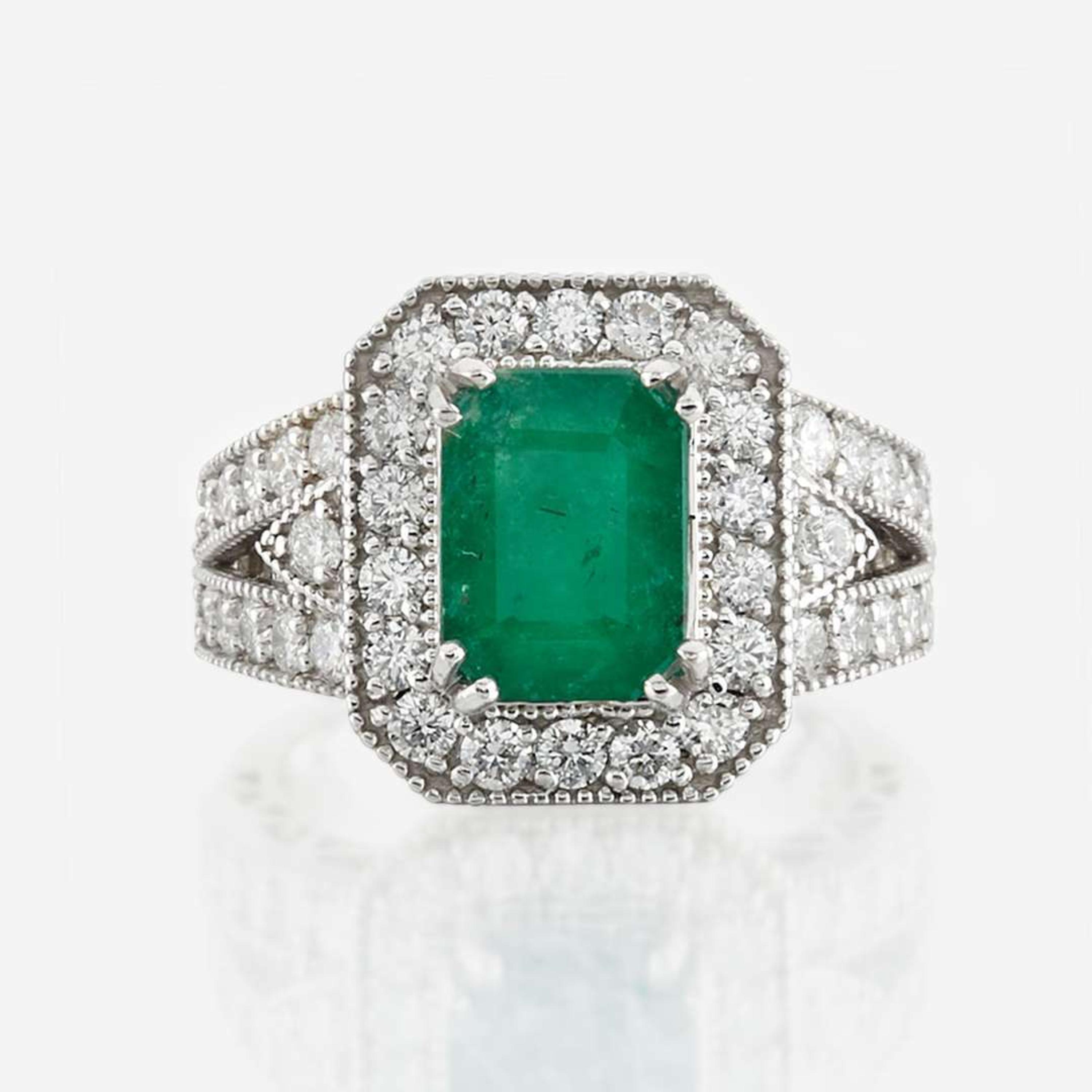 An emerald, diamond, and white gold ring