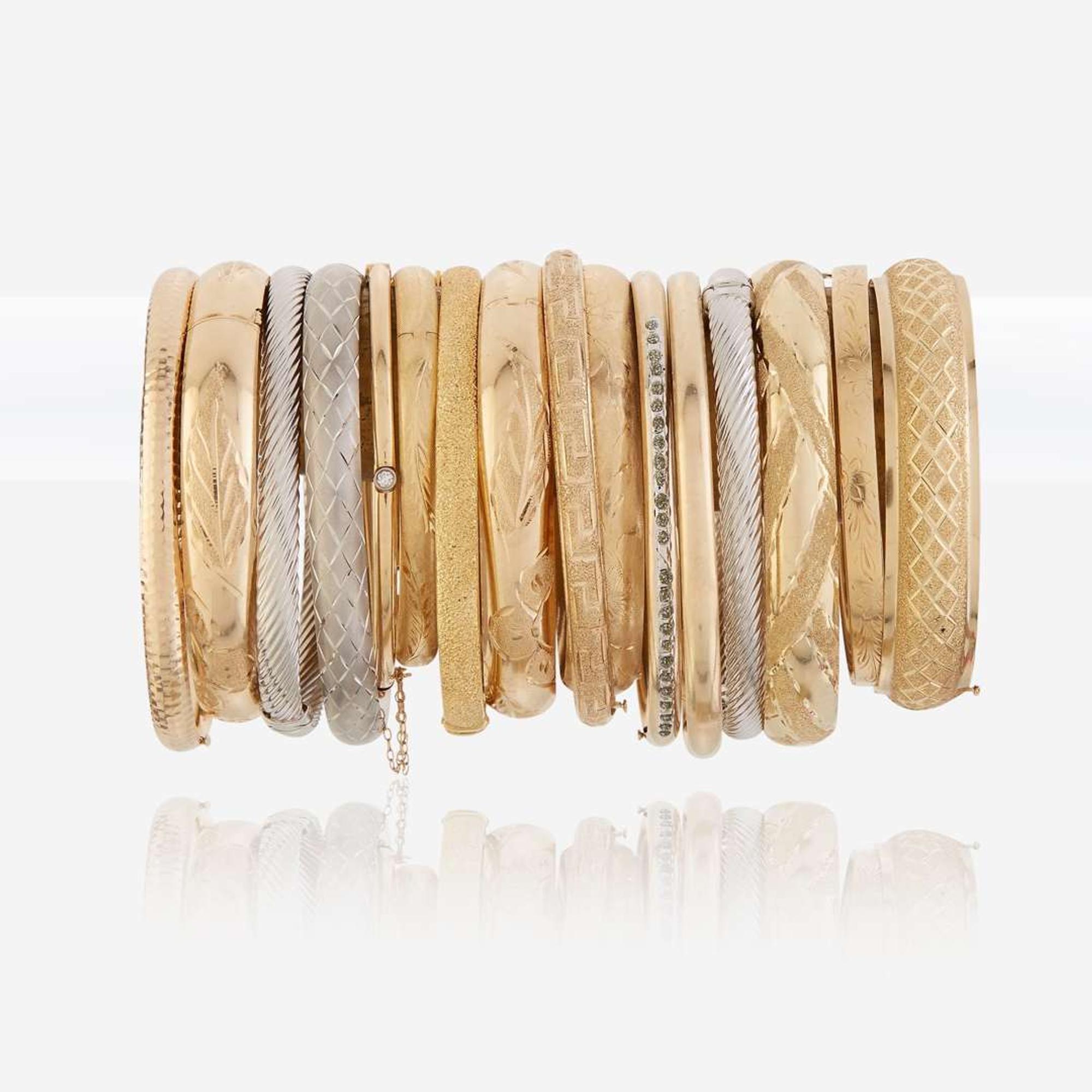 A collection of sixteen fourteen karat gold bangles