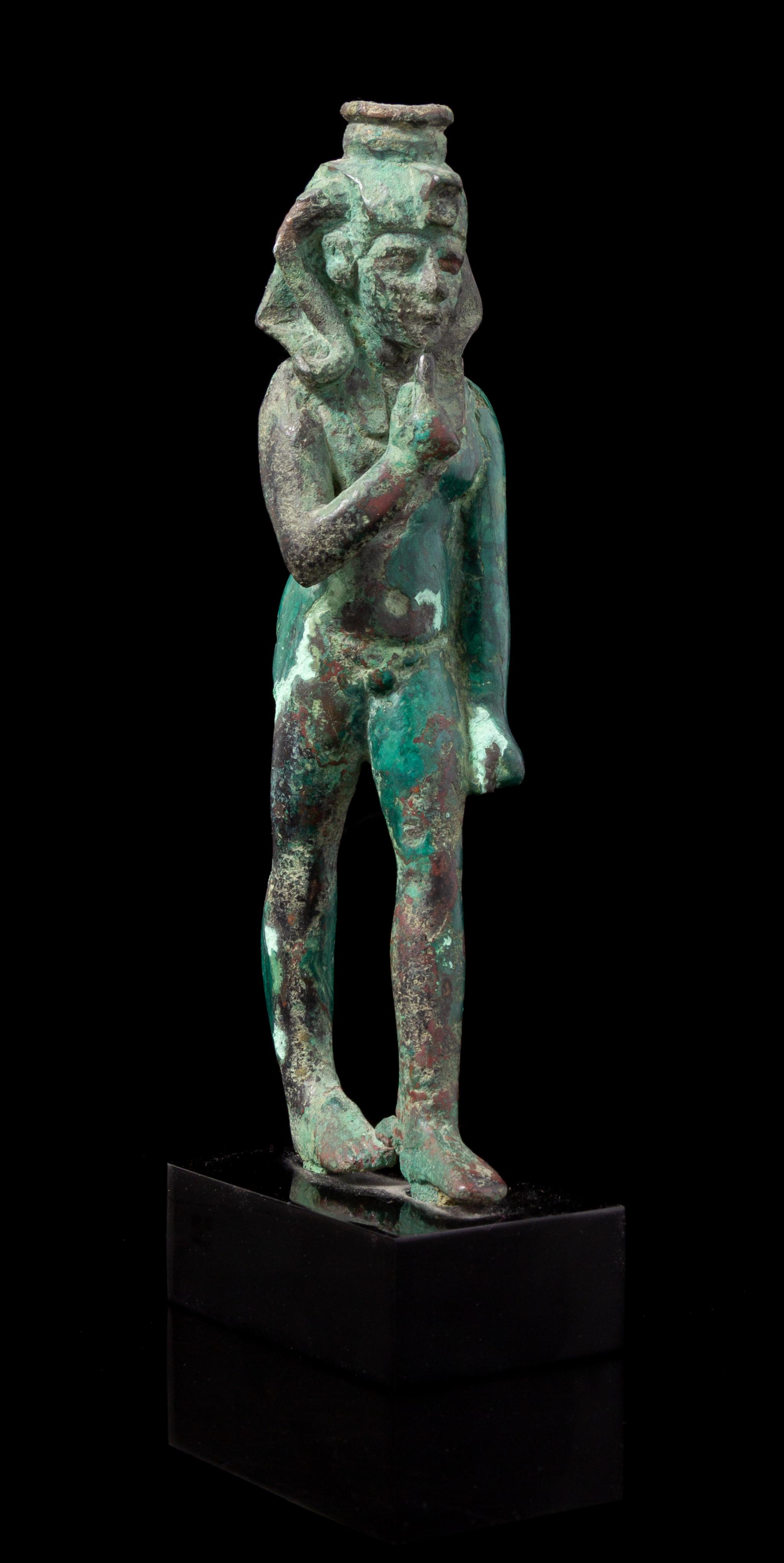 An Egyptian Bronze Striding Harpokrates Height 5 3/4 inches. — LATE PERIOD, DYNASTY 26-30, 664-343 B.C.E.