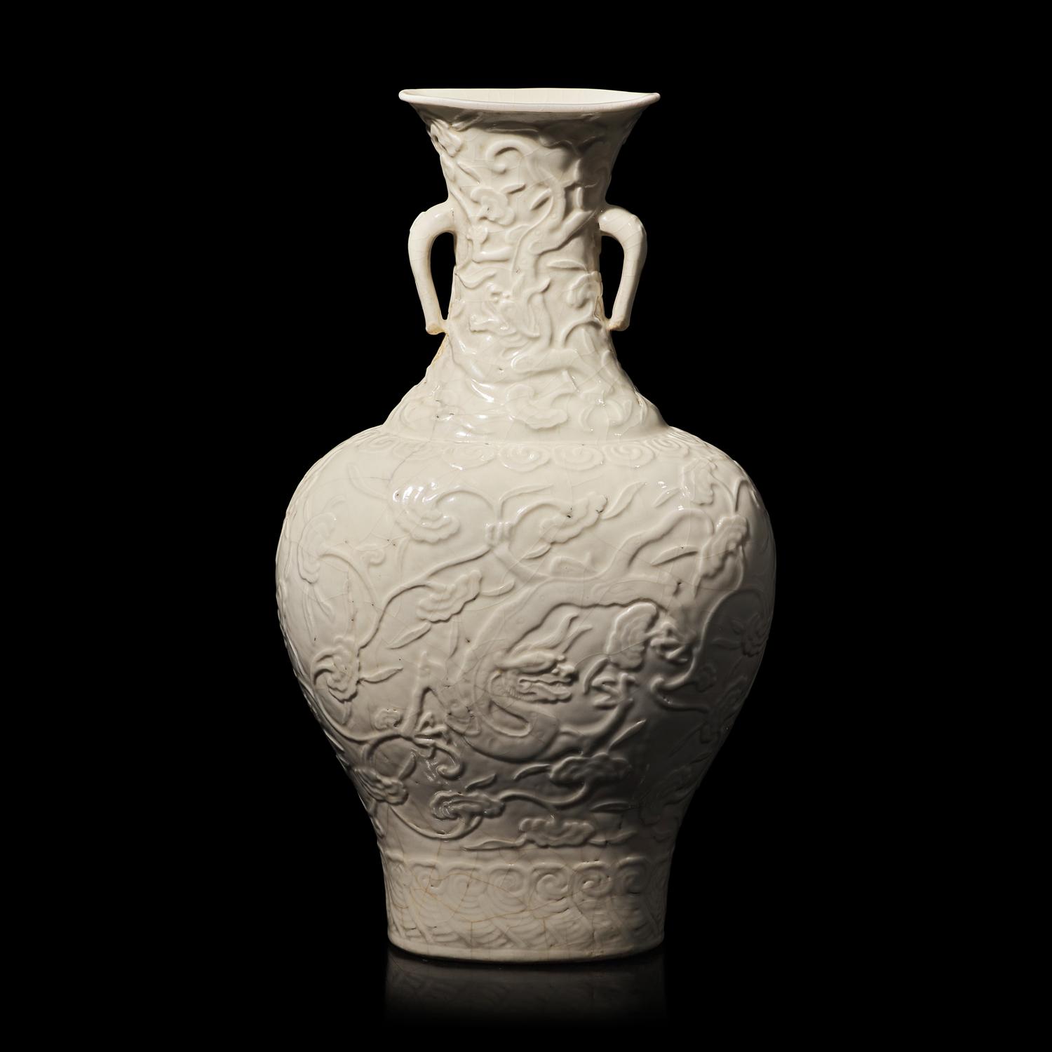 A Chinese White Glazed Soft Paste Molded 'Dragons and Lingzhi' Vase, 18th Century 清中期 白釉模印漿胎靈芝螭龍紋瓶