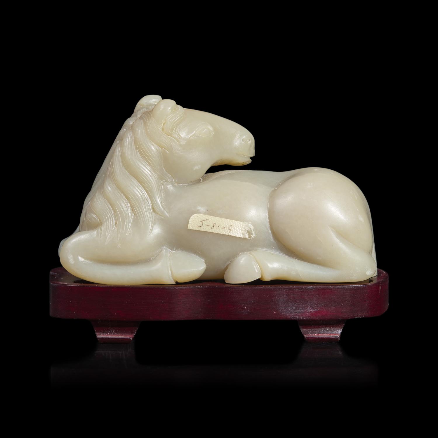 A Chinese Carved Pale Celadon Jade Horse, 20th Century 近代 青白玉臥馬