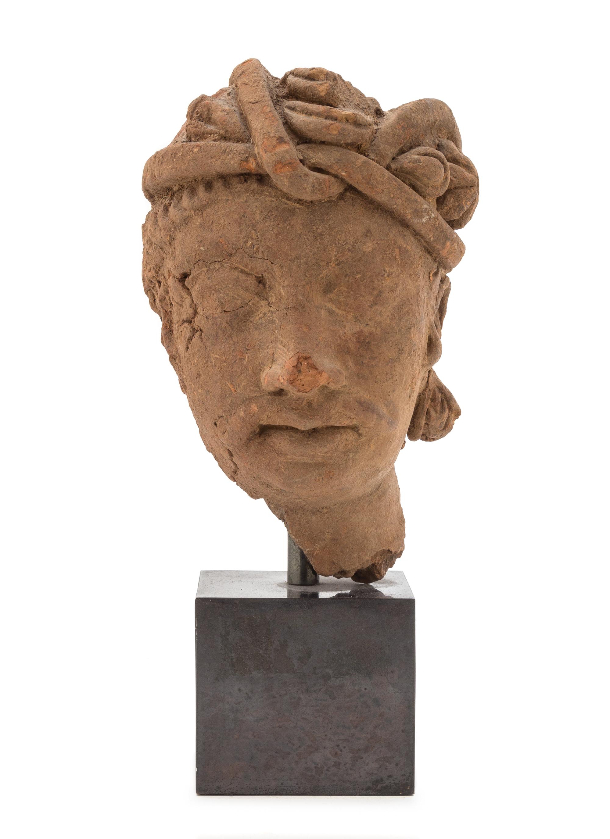 A Gandharan Terra Cotta Head of a Bodhisattva Height of head 8 inches. — HADDA REGION, 2ND CENTURY C.E.