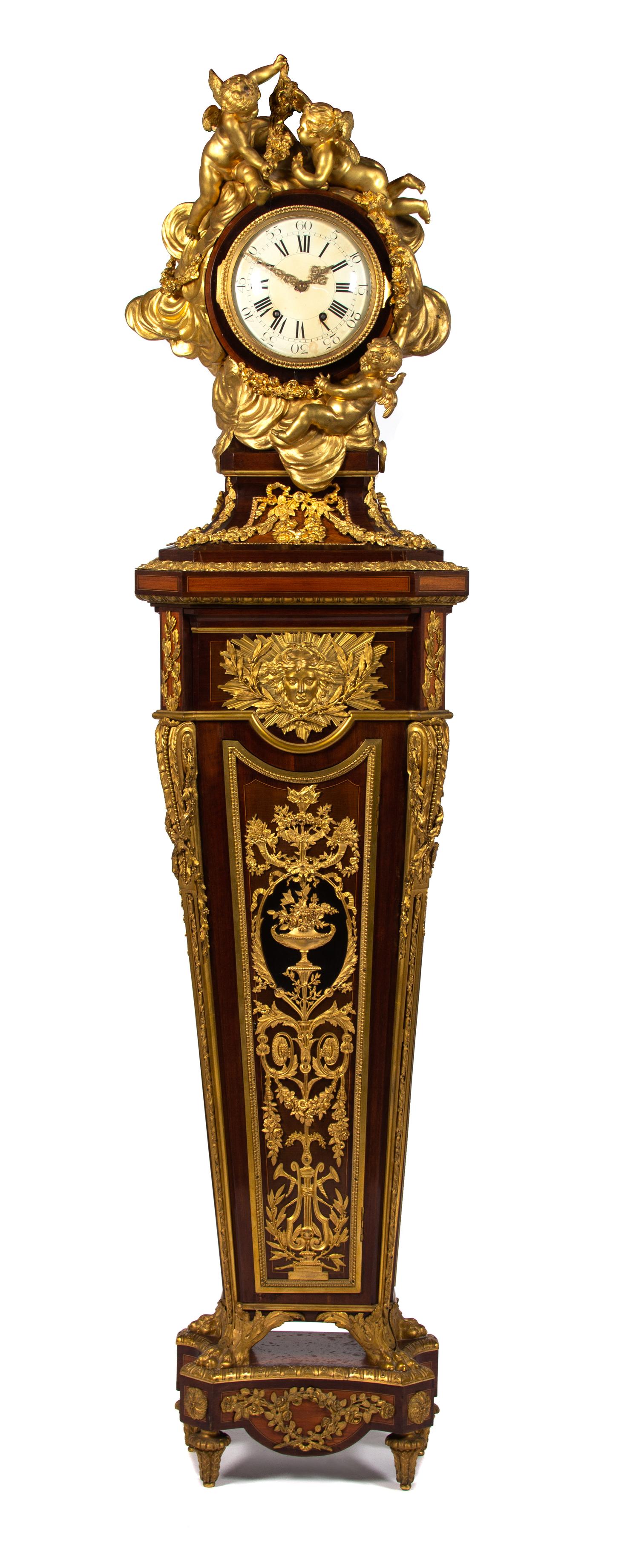 A Louis XVI Style Gilt-Bronze-Mounted Tulipwood and Kingwood Pedestal Clock Height 87 inches. — PAUL SORMANI, PARIS, AFTER THE MODEL BY HENRI REISENER, EARLY 20TH CENTURY