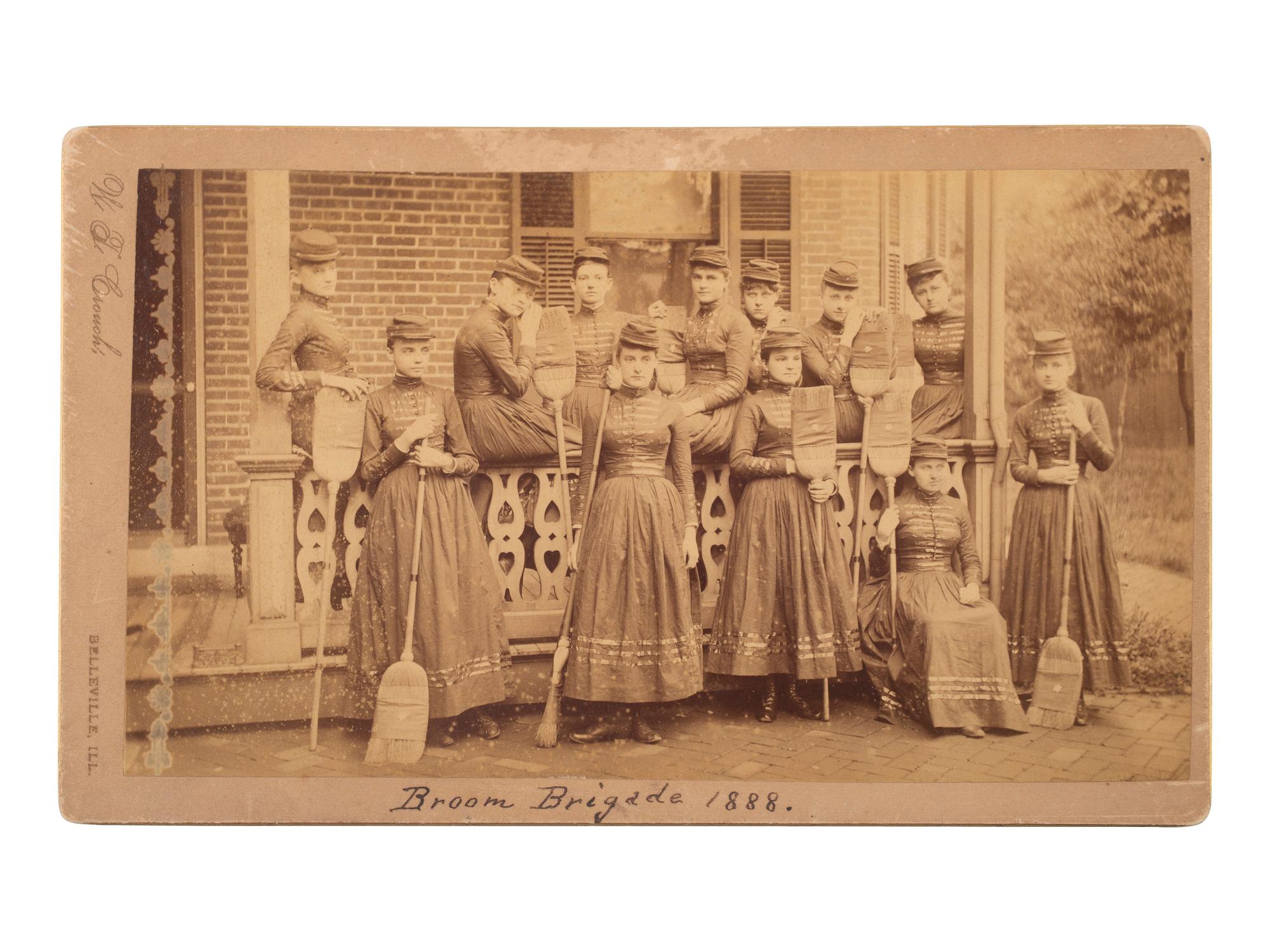 [WOMEN]. Broom Brigade 1888 . Boudoir photograph of an all-female military-style drill team.
