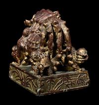 A Chinese Red and Gilt Lacquered Stone 'Buddhist Lion' Paperweight