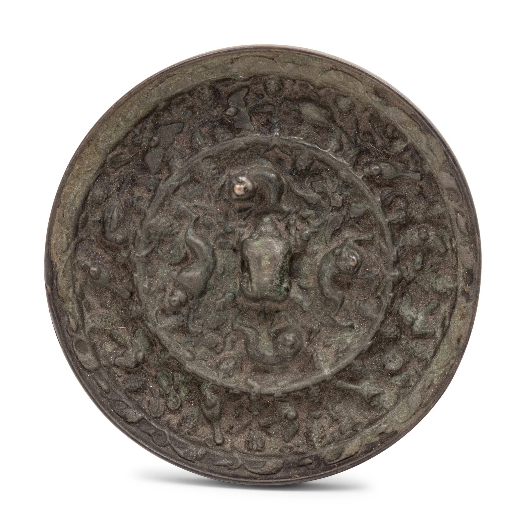 A Chinese Bronze Circular 'Mythical Beasts and Grapes' Mirror