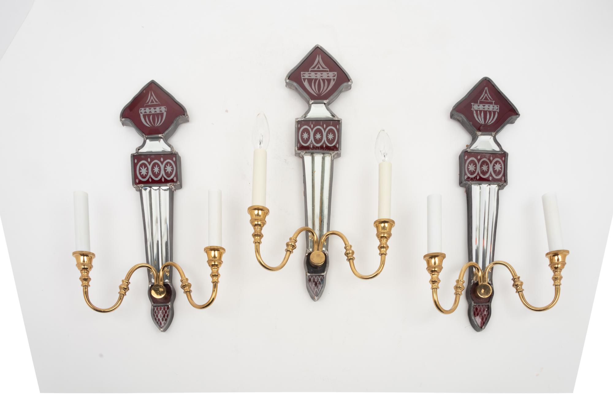 A Set of Three Mirrored, Red Glass and Brass Two-Light Sconces