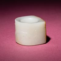 A Chinese Russet and White Jade 'Taotie and Chilong' Archer's Ring, 18th Century — 清中期 白玉留皮饕餮螭龍紋扳指