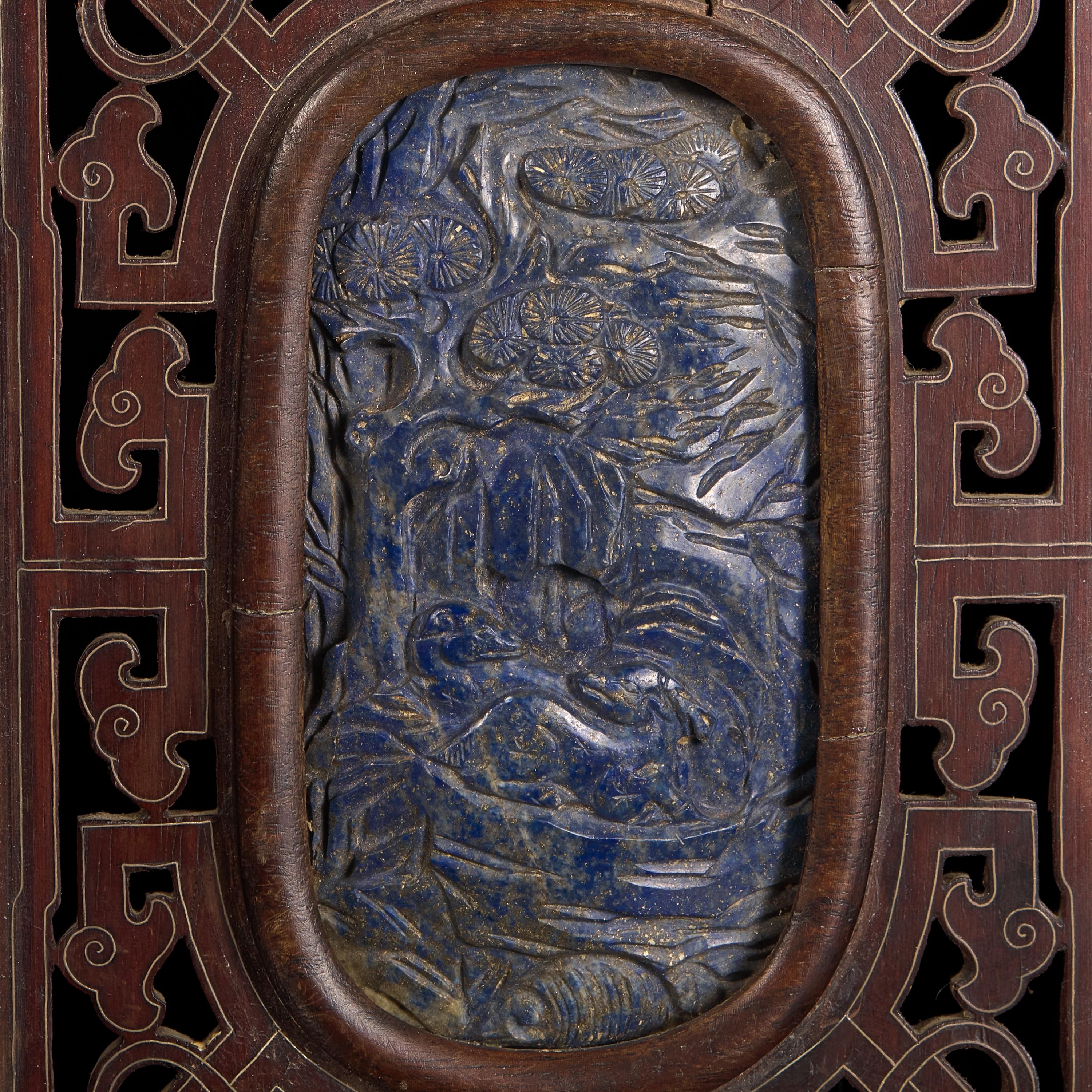 A Chinese Carved Lapis Lazuli Oval "Deer and Pine" Panel, Qing Dynasty — 清 硬木嵌青金石“鹿鶴同春”圖牌