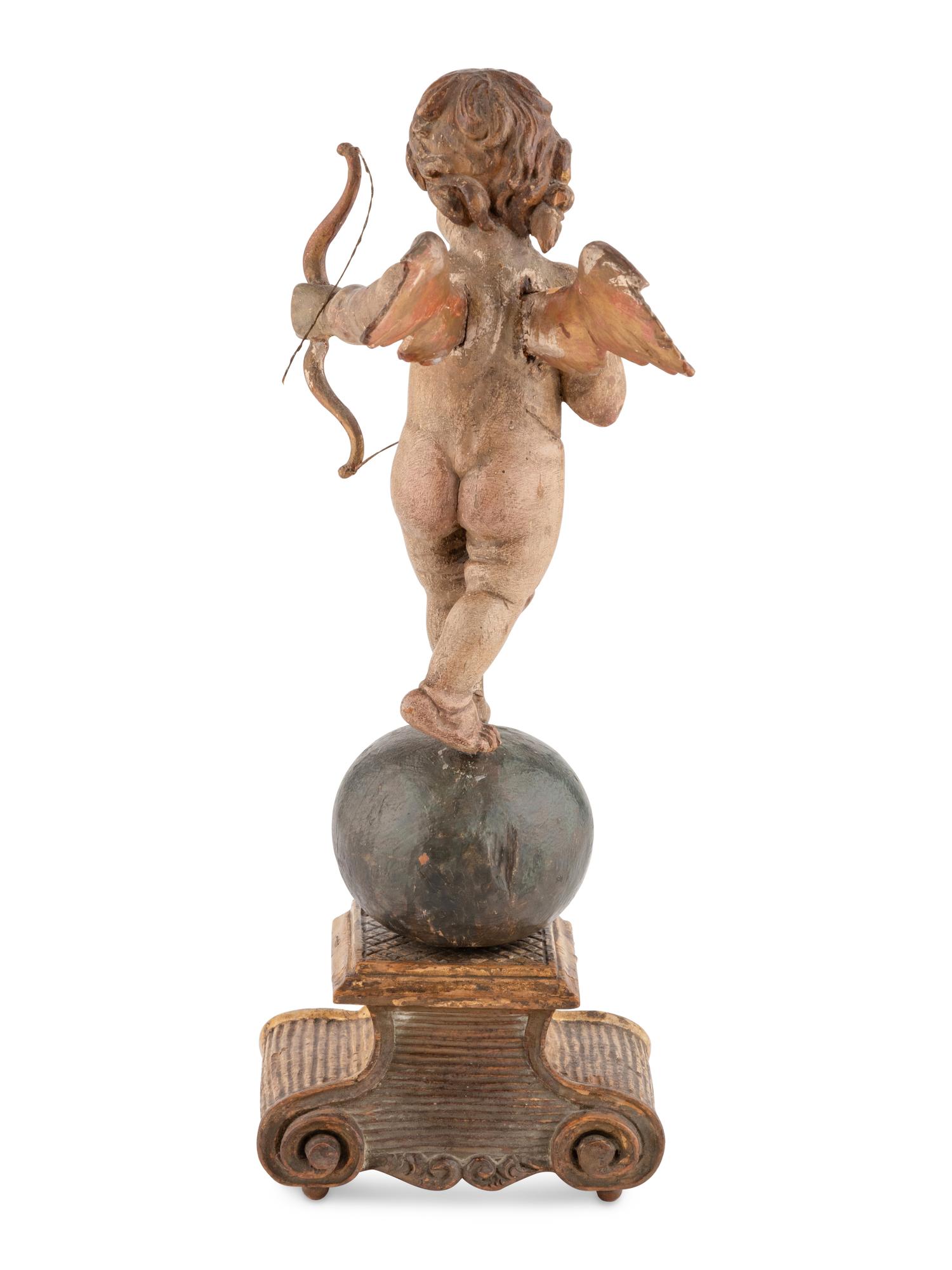 A Continental Painted and Parcel Gilt Cherub Ornament