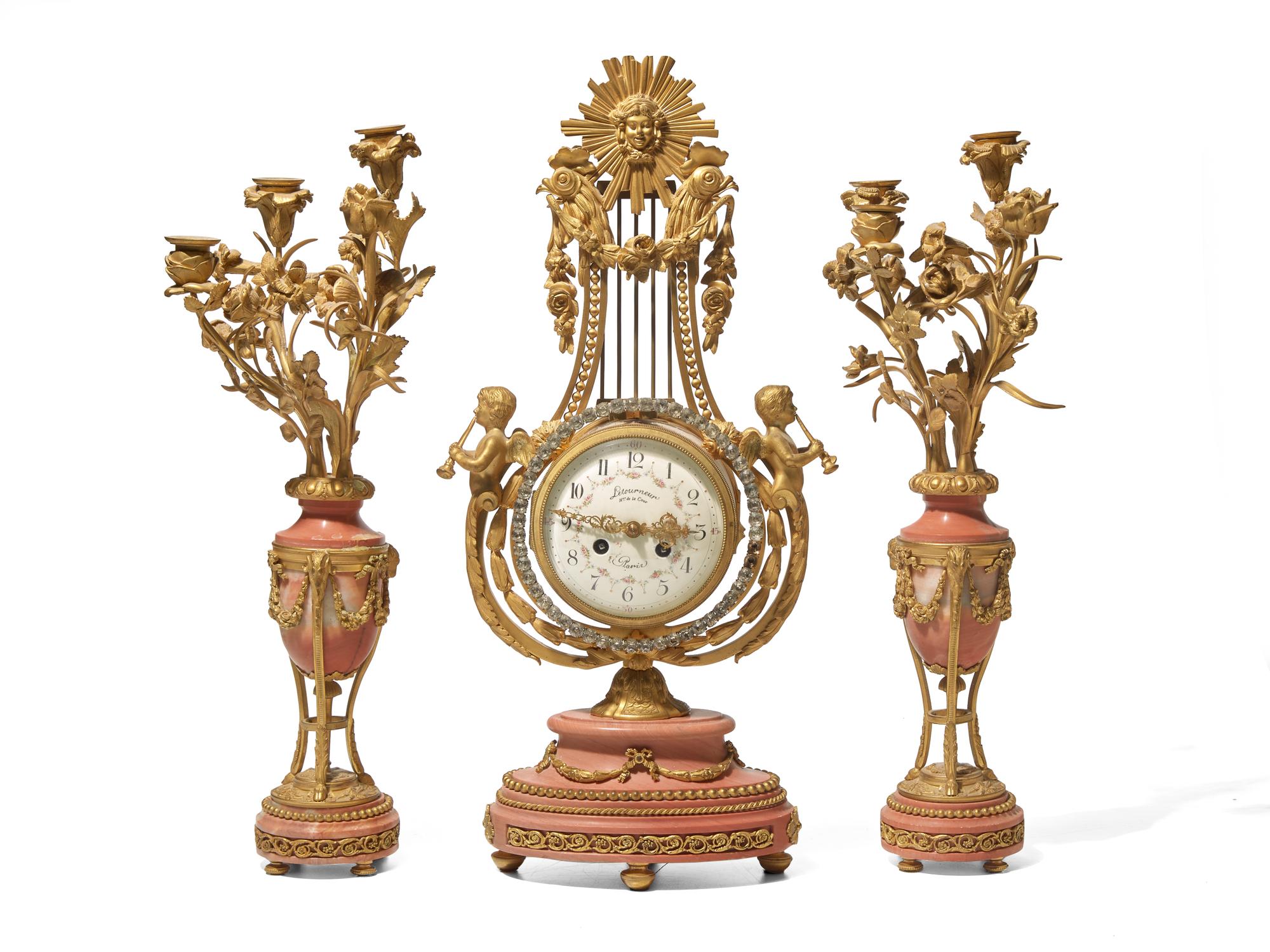 A Louis XVI Style Gilt Bronze and Pink Marble Three-Piece Clock Garniture