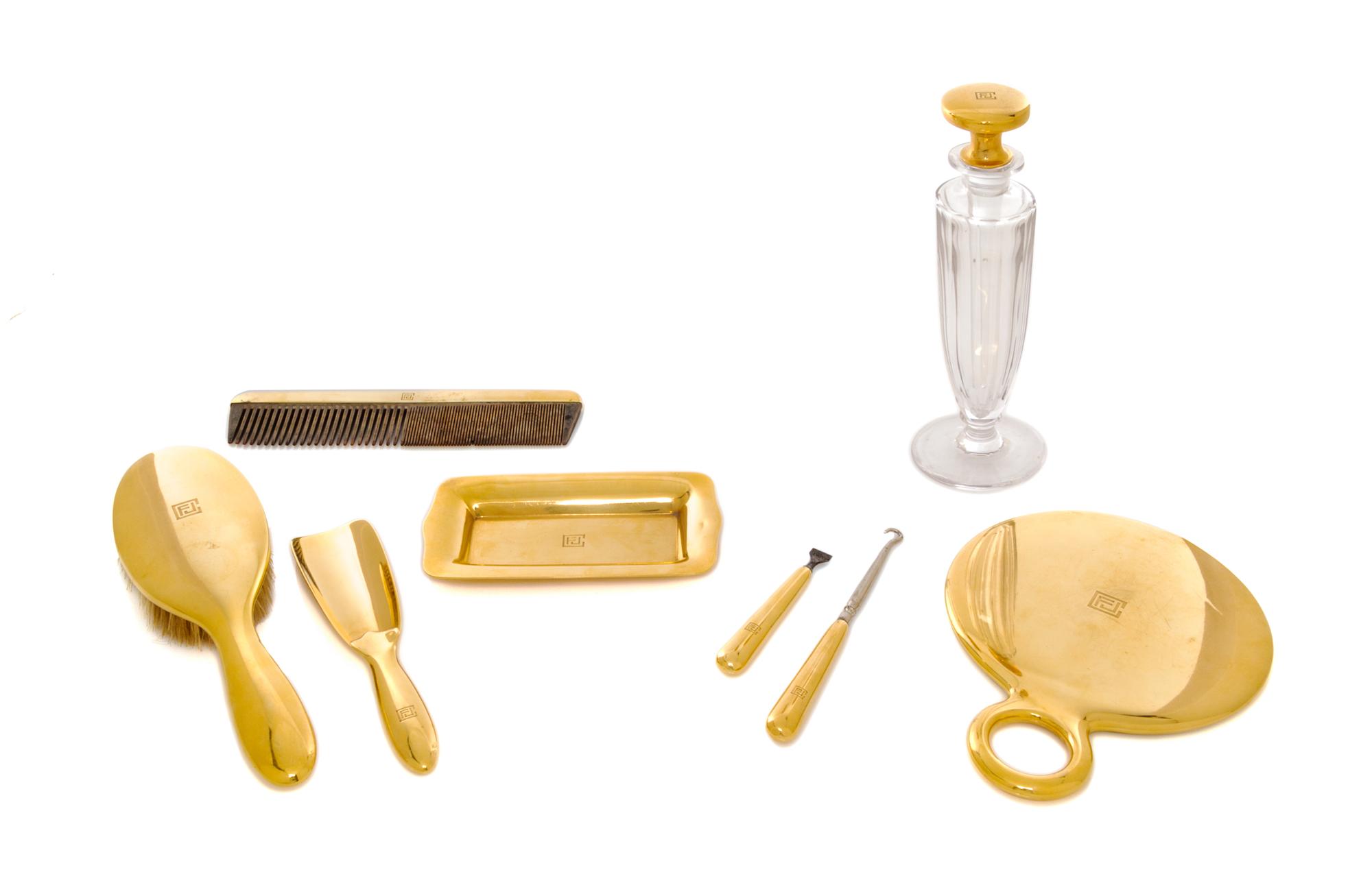 An American 18 Karat Gold Mounted Nine-Piece Dressing Set, Tiffany & Co., New York, NY, Circa 1925, all engraved with an art deco monog