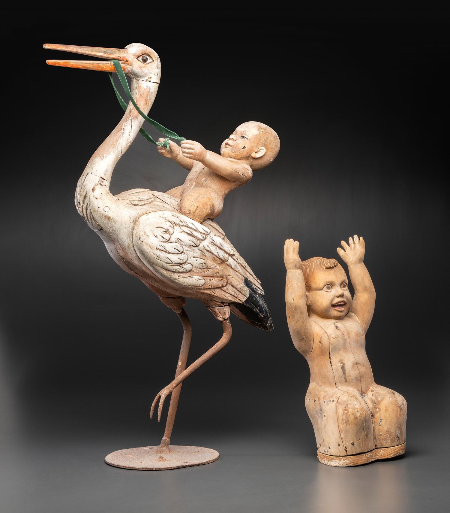 A Folk Art Carved and Painted Wood Figural Group of a Stork and Two Babies