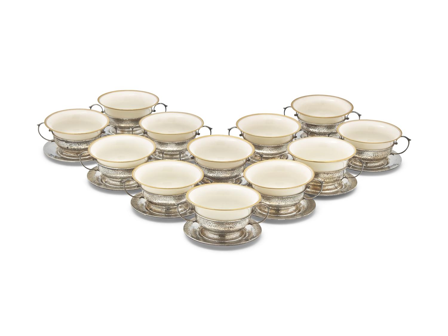 A Set of Twelve Arts & Crafts Hammered Silver Bouillon Cups And Saucers with Porcelain Liners