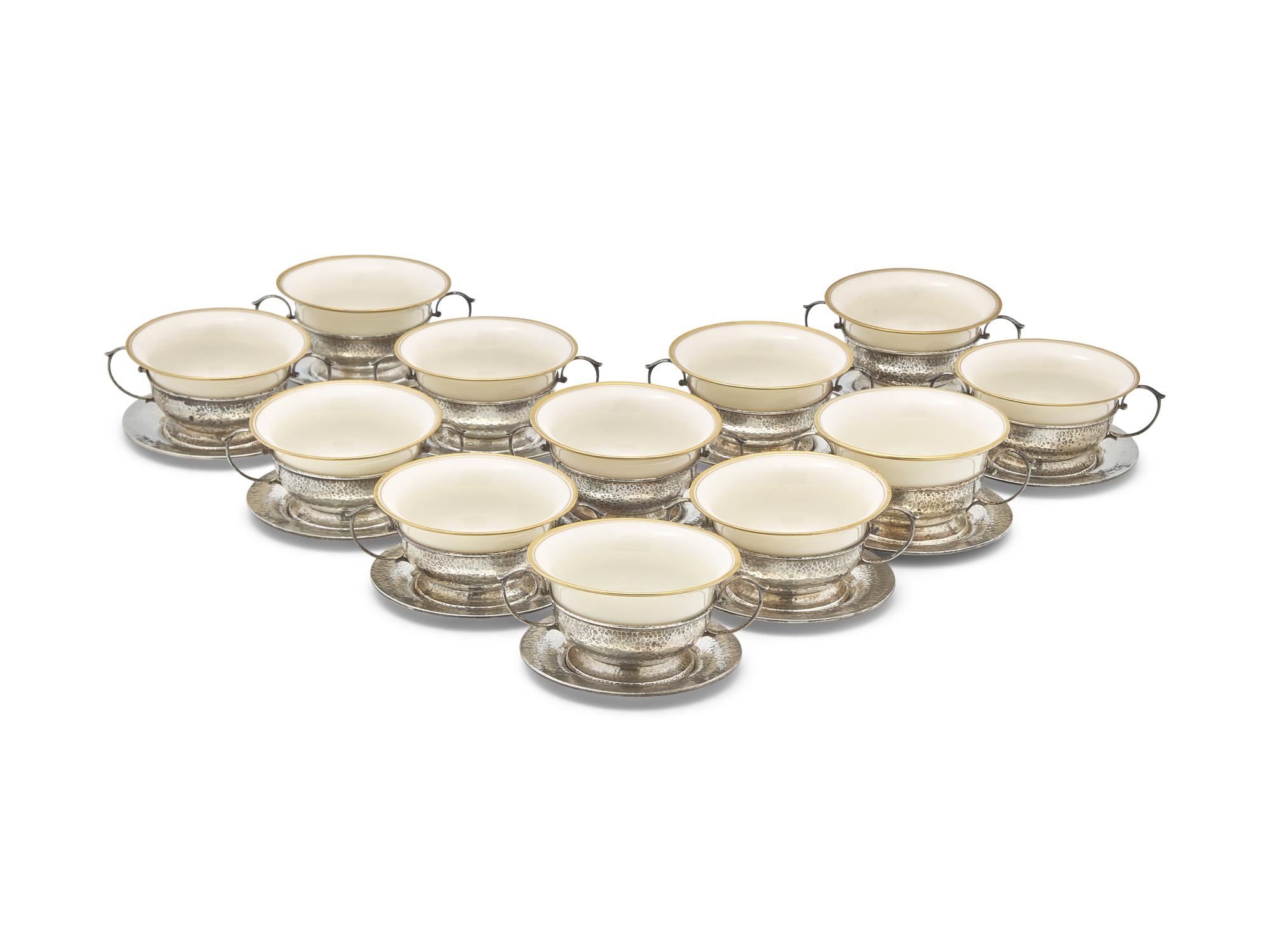 A Set of Twelve Arts & Crafts Hammered Silver Bouillon Cups And Saucers with Porcelain Liners