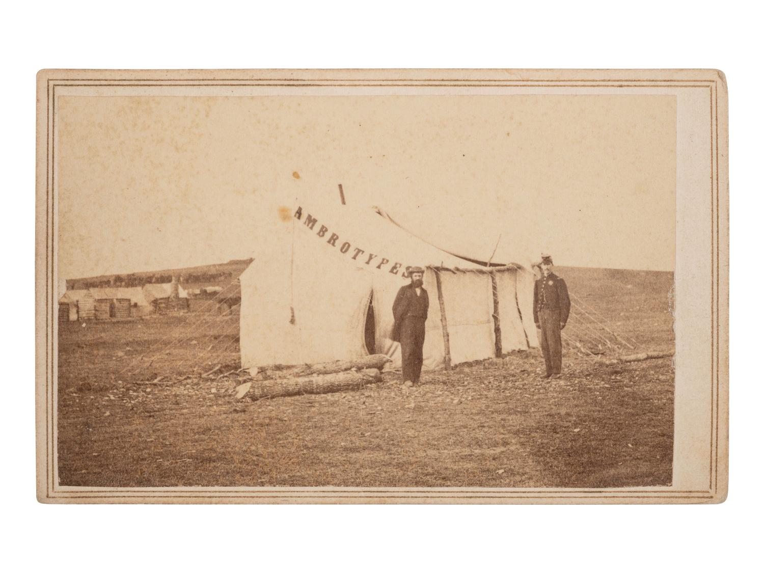 [CIVIL WAR]. CDV of a photographer's tent reading "AMBROTYPES," with the likely photographer and an officer standing just outside. Alexandria, VA: Gorman & Jordan, ca 1864.