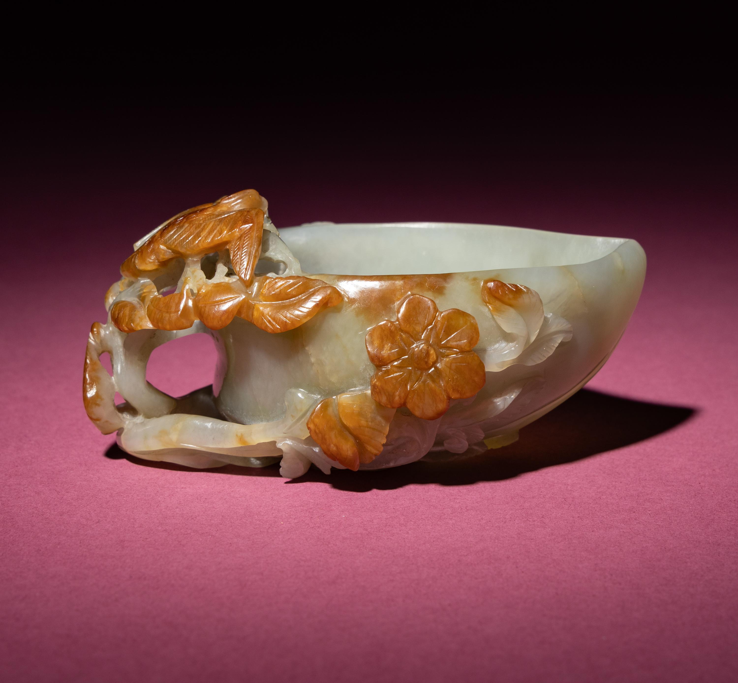 A Chinese Russet and Celadon Jade ‘Magpie and Plum Blossoms’ Peach-Form Coupe, 19th Century — 清晚期 青白玉帶皮喜上眉梢桃形杯
