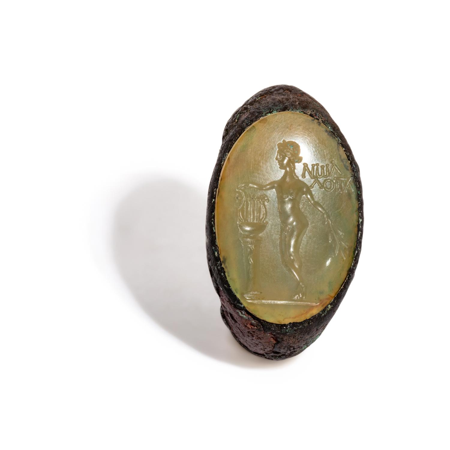 A Roman Copper Alloy and Chalcedony Finger Ring with the God Apollo