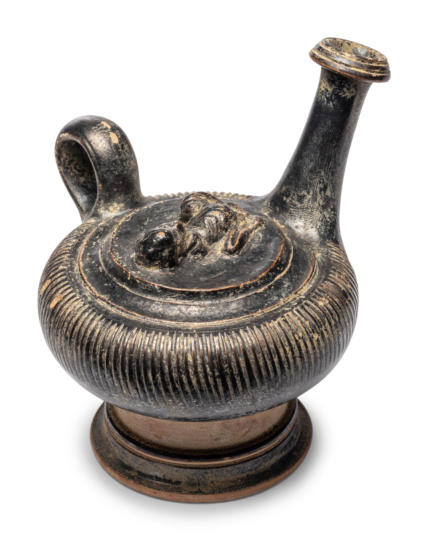 A Campanian Black-Glazed Guttus with a Grotesque