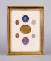 A Collection of Seven Glass Intaglios, Height of frame overall 7 3/4 inches.