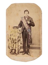 [EARLY PHOTOGRAPHY]. CDV of a young man with a cigar and intricately-tinted sash with cockades.